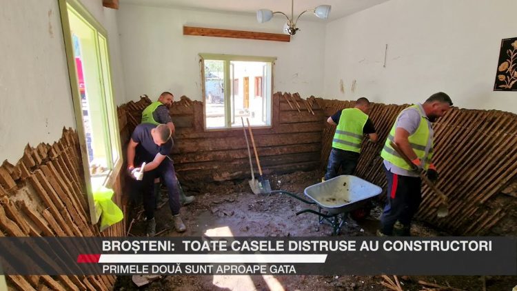 Patru muncitori lucrează la reconstrucția interioară a unei case din Broșteni, îndepărtând pereții deteriorați de inundații.