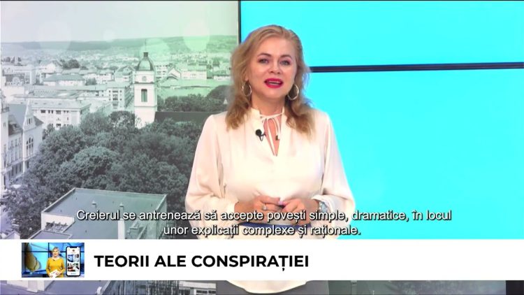 Psihologul Mihaela Paval apare într-un studio TV cu un fundal pe care scrie "Teorii ale conspirației".