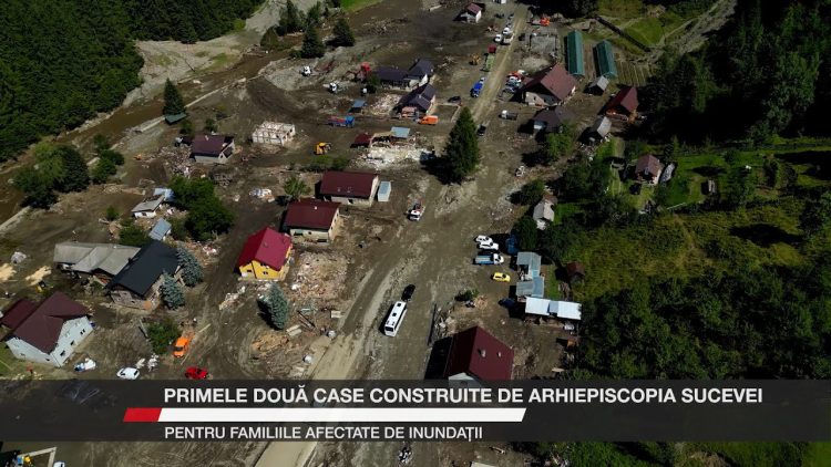 O vedere aeriană a unui sat afectat de o viitură, cu case distruse și un drum acoperit de noroi.